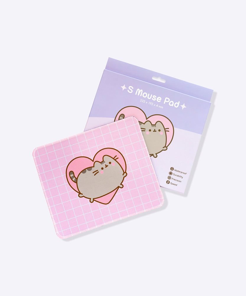 The pink with white grid pattern Pusheen Mouse Pad sits in front of its purple packaging. The packaging shows the size of the mouse pad as well as listing its features: waterproof, durability, precision, and speed. 