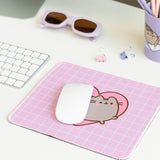Pink mouse pad on a desk with a computer mouse on top to show size and scale of the pink desk accessory.
