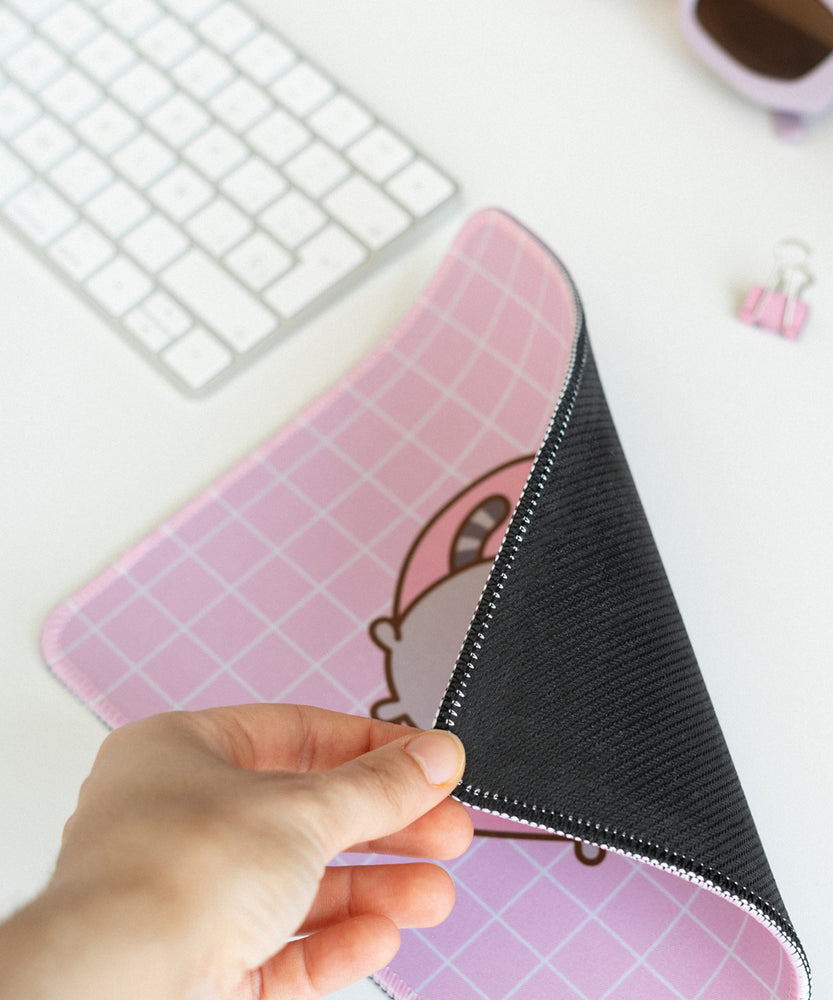 Mouse shows off the back black non-slip rubber backing of the pink and white mouse pad.