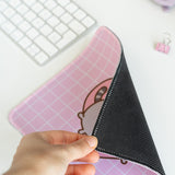 Mouse shows off the back black non-slip rubber backing of the pink and white mouse pad.