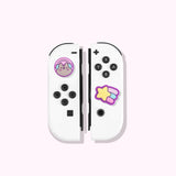 Pusheen wearing headphones and winking as a Nintendo Switch Thumb Grip on the left joy con. The grip cap on the right is a shooting star.