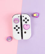 Pusheen Nintendo Switch Thumb Grip Caps on white Nintendo Switch Joy Cons. There are four different grip caps in the set. 