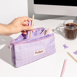 Model placing writing utensils inside of the accessory case. The interior of the three compartments can be seen.
