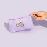 Model holds silicone pull tab on zipper of the Pusheen On Break Accessory Case. The purple case features a graphic of Pusheen the Cat winking on the front.