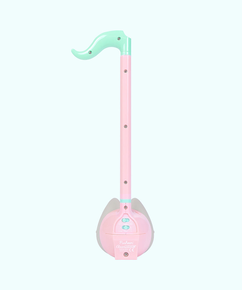 Back view of the Otamatone. The back plastic is light pink and mint green and has screws that hold the toy together.