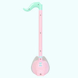 Back view of the Otamatone. The back plastic is light pink and mint green and has screws that hold the toy together.