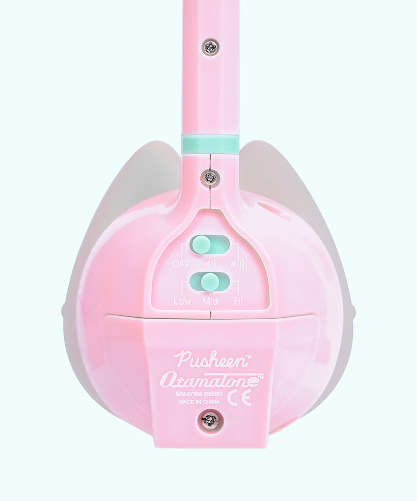 Close-up view of the back of the Pusheen Otamatone. On the back are adjustable switches to increase the volume of the toy as well as changing the pitch from low, mid, and high.