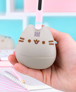 Model holds the Pusheen portion of the Otamatone in their hand to show scale of synthesizer toy.