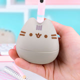 Model holds the Pusheen portion of the Otamatone in their hand to show scale of synthesizer toy.