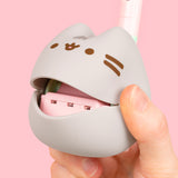 Close-up view of the musical mouth of the Pusheen Otamatone. The gray body has Pusheen's gray head stripes as well as her brown whiskers, eyes, and mouth printed in a dark brown color on the front.