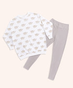 The Pusheen Patterned Loungewear Set lies on a yellow background. The set includes a cream-colored tunic top with an all over print of Pusheen the Cat in her classic grey and brown coloring. The set also includes taupe-colored legging bottoms that are folded in this image. 