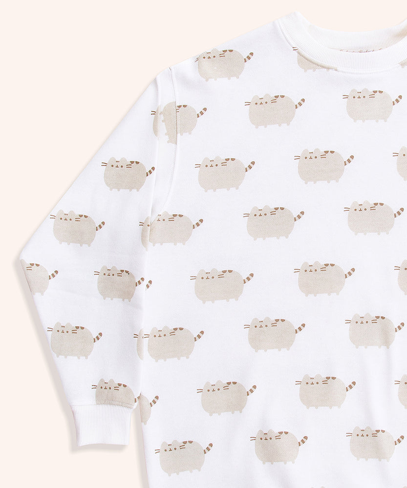Close-up view of the Pusheen Loungewear Top’s all over print. The graphics of Pusheen the Cat show her grey standing body and leggings accented with brown features: tail stripes, back stripes, head stripes, eyes, mouth, and whiskers. 