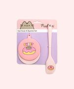 Pusheen Pet Can Cover and Spatula Set is attached to its pink and purple packaging card.