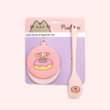 Pusheen Pet Can Cover and Spatula Set is attached to its pink and purple packaging card.