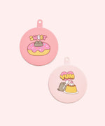 Pusheen Pet Can Cover and Spatula Set is attached to its pink and purple packaging card.