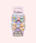 Pusheen Pet Collar Bows 2-pack attached to its packaging card. The pink and purple paper card has the Pusheen Logo and cat graphic. 