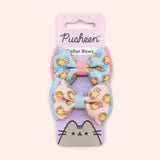 Pusheen Pet Collar Bows 2-pack attached to its packaging card. The pink and purple paper card has the Pusheen Logo and cat graphic. 