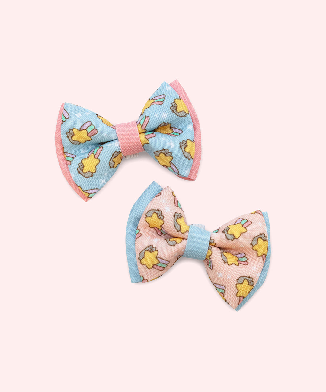 Pusheen Pet Collar Bows that can be added onto pet collars. The two bowties have a graphic of Pusheen with a shooting star surrounded by sparkles. 