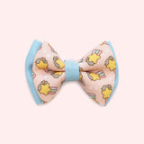 Close-up of the pink bowtie in the Collar Bows 2-pack. The main bowtie background color is pink and has blue piping details. 