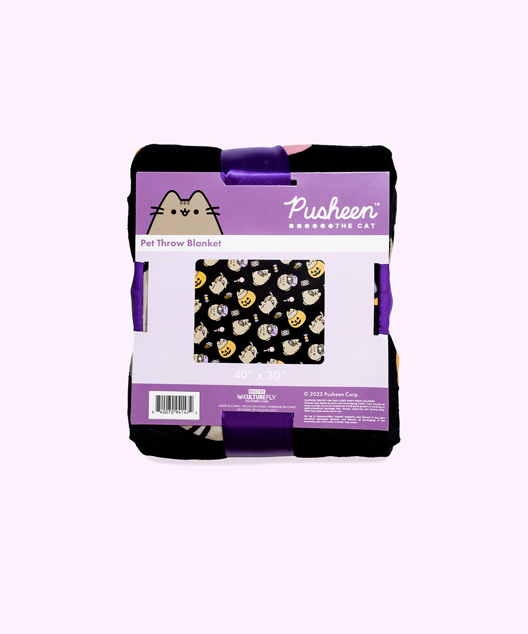 The Halloween blanket is folded inside its packaging which states that it is a “Pet Throw Blanket.” The packaged black blanket sits in front of a light purple background. 