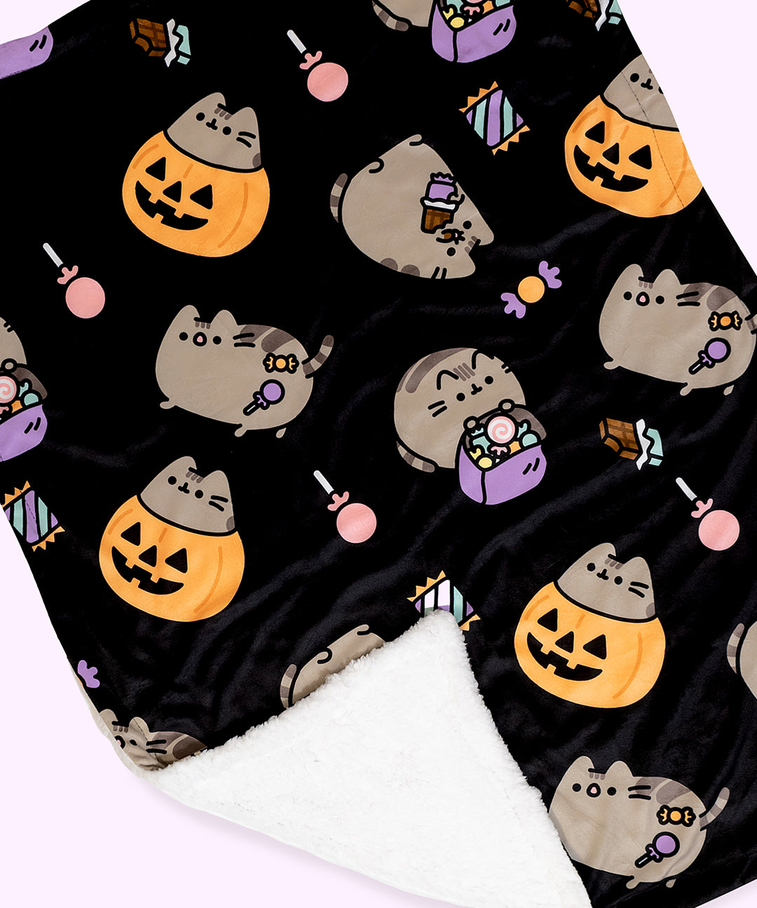 Close-up view of the Pusheen Pet Blanket. The black background micro flannel side has a white sherpa material on the reverse side.  