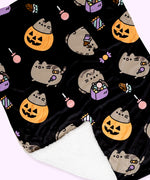 The Halloween blanket is folded inside its packaging which states that it is a “Pet Throw Blanket.” The packaged black blanket sits in front of a light purple background. 