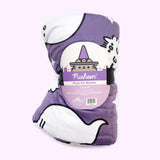 The Halloween Pet blanket is rolled inside its packaging which states that it is a “Pusheen Plush Pet Blanket.” The packaged black blanket sits in front of a light purple background. 