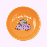 Close-up pf interior print on Pusheen Pet Halloween Pedestal Bowl where a gray tabby cat sits on a pile of Halloween candy.