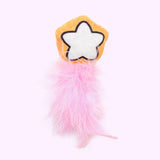 Close-up of the orange and white star plush pet toy with pink feathers attached to the bottom. 
