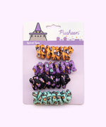 Close-up of mint green spiral cat toy that has a pattern of Witchsheen wearing a purple hat and riding a broom surrounded by pumpkins and ghosts.