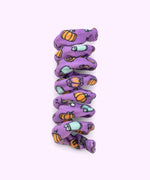 Close-up of purple spiral cat toy that has a pattern of Zombie Pusheen and Bat Pusheen with orange pumpkins and black stars.