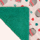 Close-up view of the Pusheen Pet Holiday Blanket. The light pink background micro flannel side has an dark green sherpa material on the reverse side that matches the color of the green peppermints and gumdrops on the reverse side.