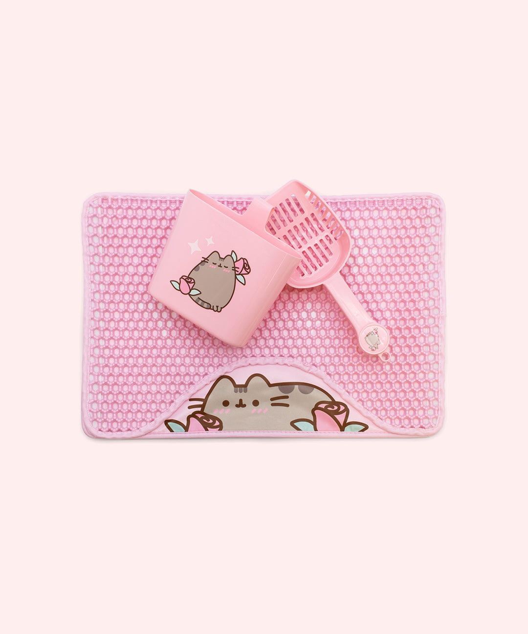 Components in the Pusheen Pet Litter Scoop and Mat Set. The Set includes a floor mat, scoop, and scoop holder. All three pink items have Pusheen designs with rose graphics.
