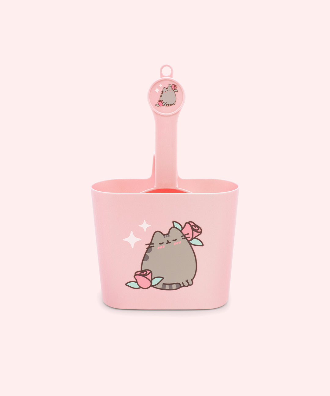 Pink litter scoop and scoop holder have Pusheen the Cat designs with roses. The scoop holder has a ledge to hang over the box.