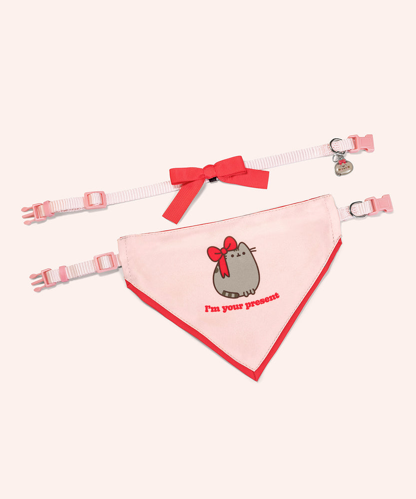 Pusheen pet Holiday-themed collar and bandana set laid out to show the length of the collars and the size of the printed bowtie and bandana. The light pink and red set rests on a light purple background. 