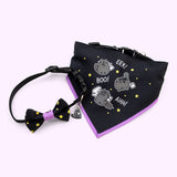 Front view of Pusheen Pet Scaredy Cat Collar & Bandana Set. The black collar has an attached bowtie with yellow stars and a Pusheen Scaredy Cat charm. The bandana has a black background and three graphics of Pusheen as a scaredy cat with a little white ghost friend. 