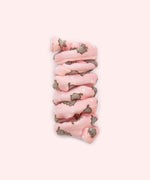 Close-up of pink spiral cat toy that has a pattern of Pusheen the Cat blushing and surrounded by white sparkles.