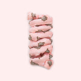 Close-up of pink spiral cat toy that has a pattern of Pusheen the Cat blushing and surrounded by white sparkles.