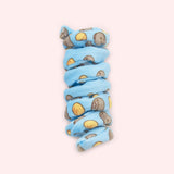 Close-up of blue spiral cat toy that has a pattern of Pusheen the Cat in a loaf pose with a yellow loaf of bread. 