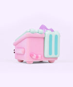 Back and side view of the Pusheen toy. The pink fuzzy dumpster sits on four legs, has side handles, and mint green top lids. On the back of the toy is Pusheen’s striped tail in alternating pink colors. Coming out of the top of the toy figure is pastel purple flames. 