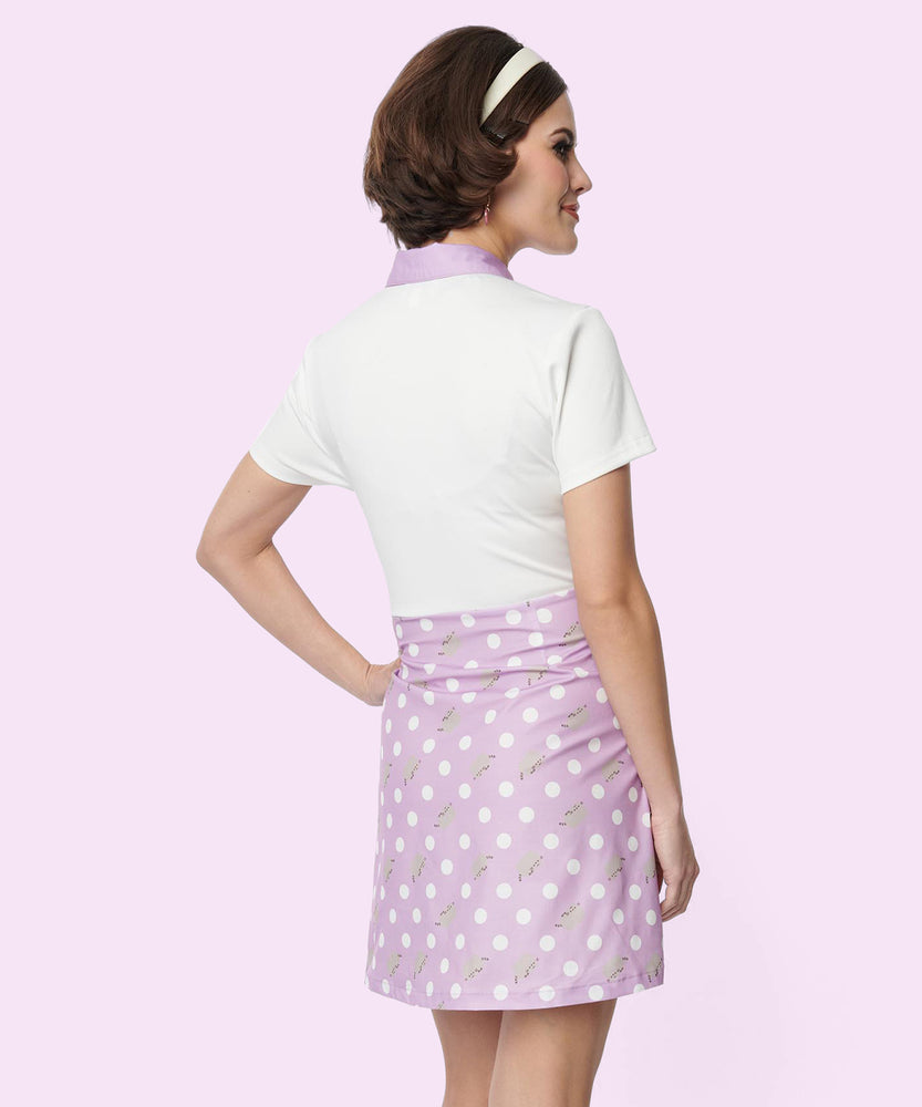 Model shows off the back of the purple Pusheen Dress. The purple polka dot shift dress has a white short-sleeve top and purple skirt bottom.