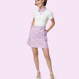 Model stands in Pusheen Purple Polka Dot Dress. The Pusheen pattern on the skirt of the dress has white polka dots and grey, laying Pusheen the Cats.  