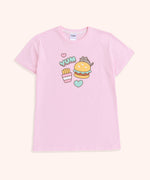 A close-up view of the Snack Time Pajama Tee. The pajama shirt features a graphic of Pusheen climbing atop a juicy hamburger with a sesame seed bund. Next to Pusheen, is the phrase “YUM”, pink, and mint green hearts, and a packet of French fries.  