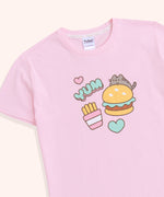 A close-up of the graphic on the front-center of the light pink, unisex pajama top. The grey and brown tabby cat is accompanied by a yellow, green, and brown hamburger, pink and mint green hearts, and yellow, pink, and white fry's packet. 