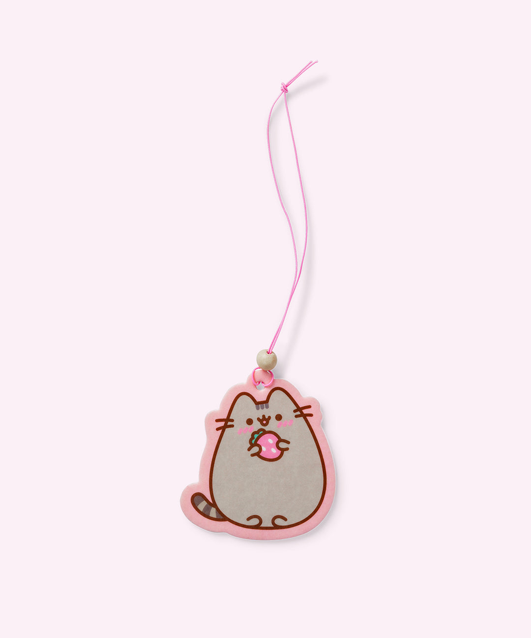 Front view of 1 of the 2-pack of Pusheen Air Fresheners. A strawberry-scented Pusheen graphic of a blushing cat holding a pink strawberry hangs on a pink elastic string. 