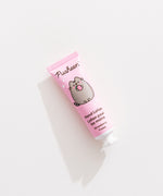 Close-up of the Pusheen hand lotion tube that is strawberry scented and has pink packaging. 