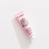 Close-up of the Pusheen hand lotion tube that is strawberry scented and has pink packaging. 