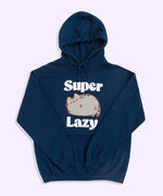 A navy-blue graphic hoodie lies against a light purple background. The unisex hoodie has a screen-printed graphic on the center of the chest showing Pusheen the Cat winking while surrounded by the phrase “Super Lazy” in white puff print. The blue hoodie strings are tied in a bow. 