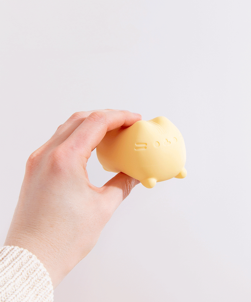 Model squishes yellow squishy toy with fingers. The gel-filled toy squishes like a stress ball.