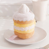 Side back view of the Pusheen Lemon Cake Plush. The middle cake, custard, and whipped cream layer embroidery continues all the way around the plush. 